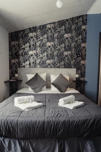 a bedroom with a bed with two towels on it at le Bistrot des Portes in Les Portes