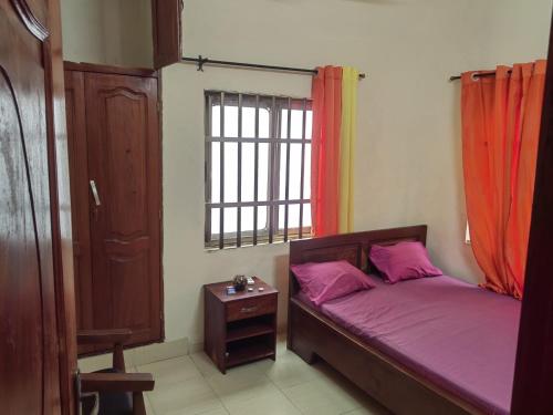 a small bedroom with a bed and a window at Appartement 2 chambres salon in Cotonou