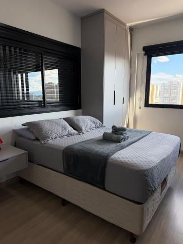 a bedroom with a large bed with a window at Fully equipped apt: A/C, pool & gym in Downtown in Taubaté