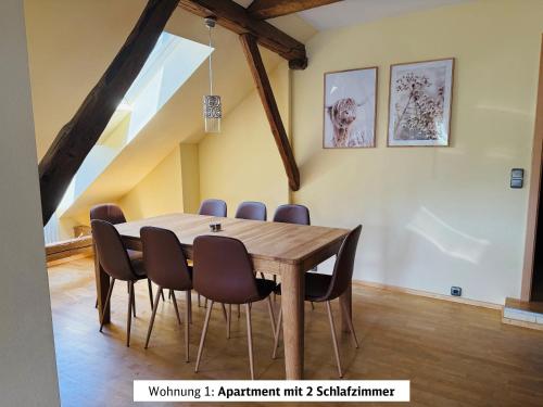 a dining room with a wooden table and chairs at Schads Bergheimat in Wertach
