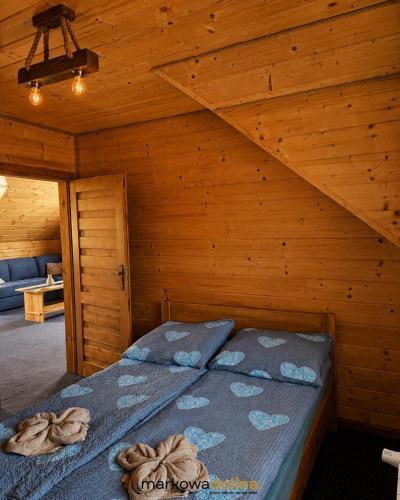 a bedroom with a bed in a wooden room at Apartamenty Markowa Dolina in Rymanów
