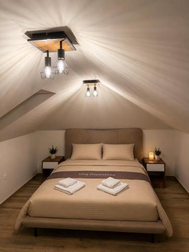 a bedroom with a bed with two towels on it at Villa Royalstone in Donja Ralja