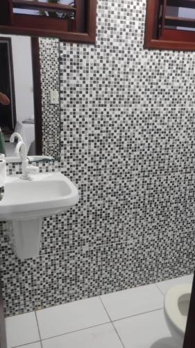 a bathroom with a sink and black and white tiles at Pousada dos Marujos in Pipa