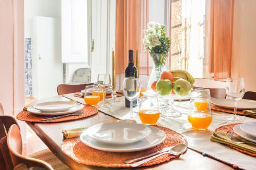 a dining room table with plates and glasses of orange juice at Coeur de Fern in Lisbon