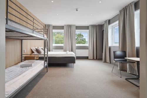 a bedroom with two bunk beds and a desk at Måby Park Hotel Arlanda in Arlanda