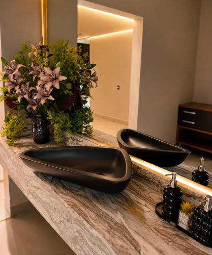 two black sinks on a counter in a bathroom at Hotel Dal Flora in Sorriso