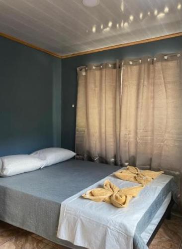 a bedroom with a bed with towels on it at Casa Colibrí #1 in Puerto Jiménez
