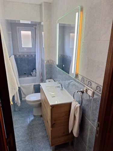 a bathroom with a sink and a toilet and a mirror at Casa de la güela in Avilés