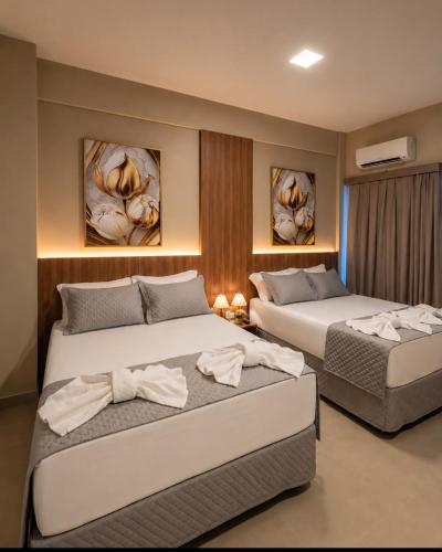 two beds in a hotel room with two beds at Hotel Dal Flora in Sorriso
