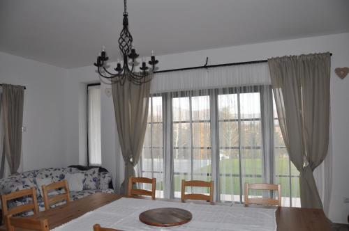 comedor con mesa y sillas y ventana grande en Villa De Dominique, en Erdőbénye