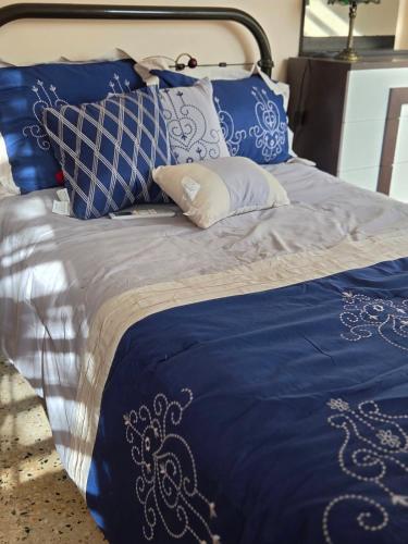 a bed with blue and white pillows on it at La Abuela Hospitality in Dorado