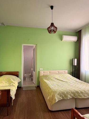 two beds in a room with green walls at Light in August in Kobuleti