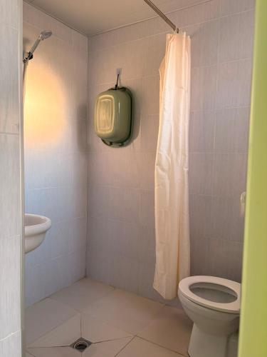 a bathroom with a toilet and a tv on the wall at Light in August in Kobuleti