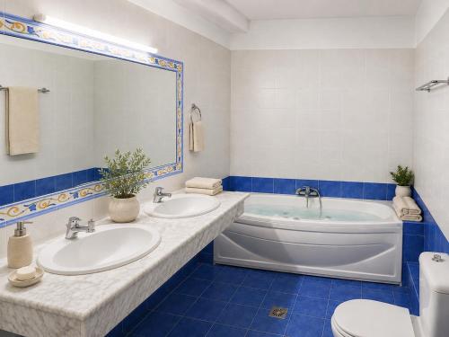a blue and white bathroom with two sinks and a tub at Villa Kallergi Nefeli in Loutra