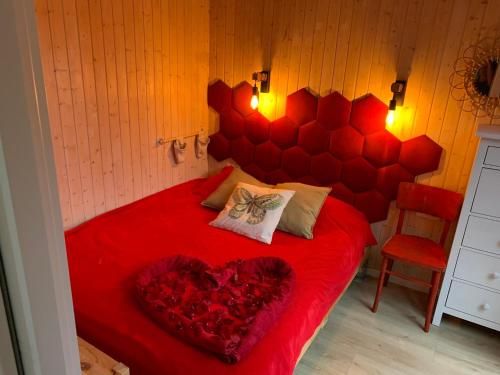 a bedroom with a red bed with a heart pillow at POLA Łupawsko in Łupawsko
