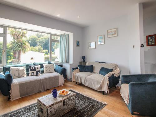 a living room with a couch and a chair and a table at Anchor Cottage in Salcombe