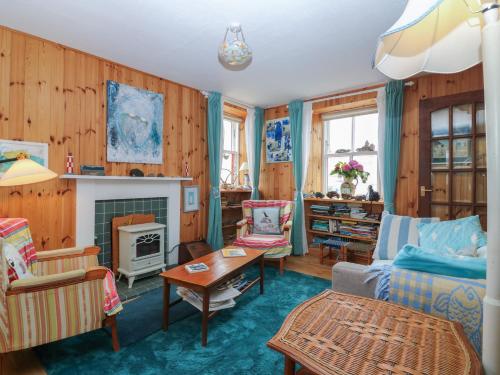 a living room with wooden walls and a fireplace at Dookers' Hoose in Buckie