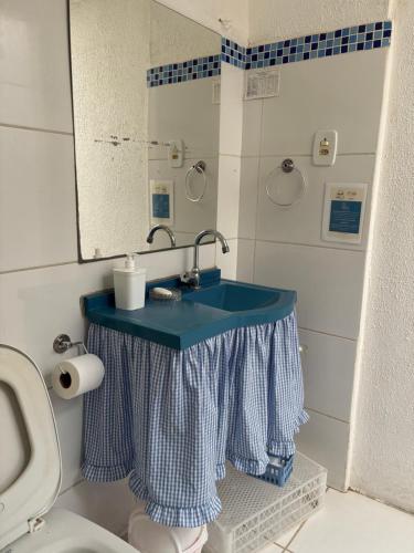 a bathroom with a blue sink and a toilet at Casarão Centenário in Passos