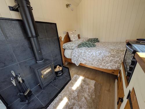 a room with a stove and a bed in a room at The Beeches in Scarisbrick