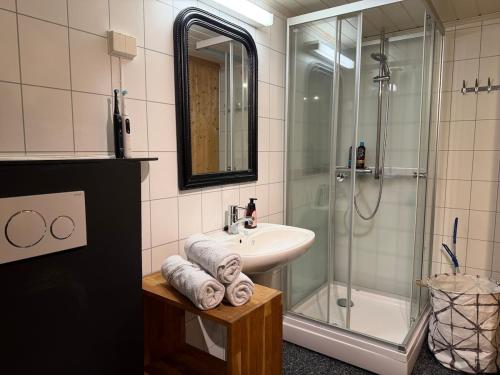 a bathroom with a sink and a shower with towels at Apparent with 2 bedrooms for rent in Kirkenes