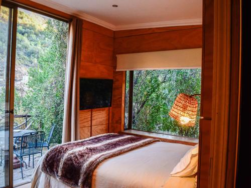 a bedroom with a bed and a large window at Casa Nilhue Camino a Farellones in Lo Barnechea