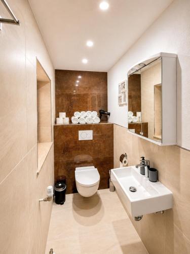 ein Badezimmer mit weißer Toilette und Waschbecken in der Unterkunft FeWo Central Rust in Rust