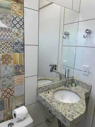 a bathroom with a sink and a mirror at D` Garcia Hotel in Três Lagoas