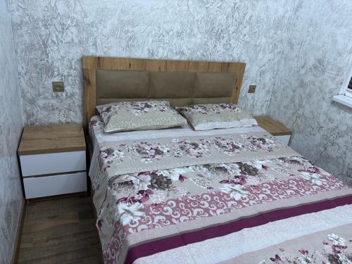 a bedroom with a large bed with a wooden headboard at Apartment in Jvari in Jvari