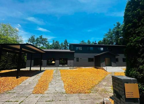 a house with a lot of leaves on the ground at Tanglin Maison Hakuba by Jade Villa in Hakuba