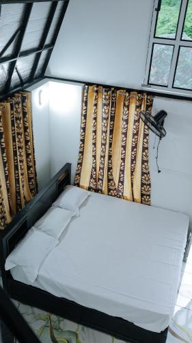 a bed in a room with a window at Sansa Villa in Athirappilly