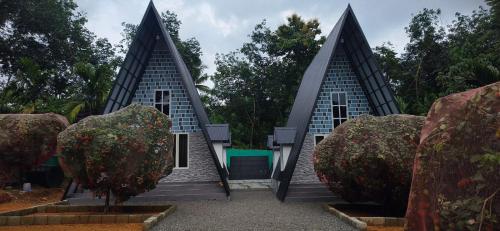a small house with two peaked roofs in a garden at Sansa Villa in Athirappilly