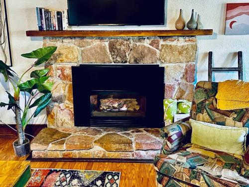 a living room with a stone fireplace with a tv on top at Orange Door Electric Fireplace bbq in Oakhurst