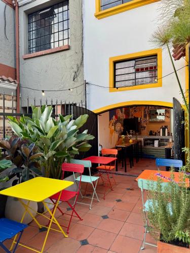 a patio with colorful tables and chairs in front of a building at Vecinos by La Palmera in Bogotá