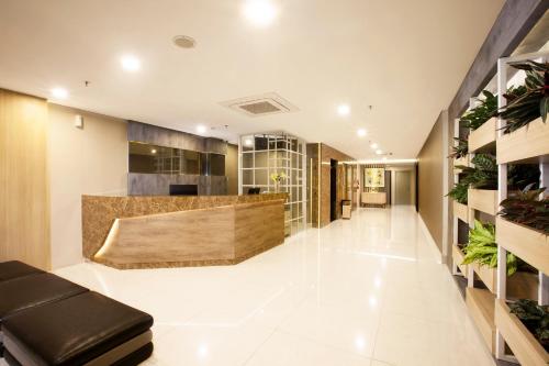 a living room with a wooden floor and a large window at Verse Lite Hotel Gajah Mada in Jakarta