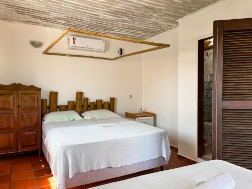 a bedroom with a large white bed and a window at Wind & Sun Kite Pousada in Canoa Quebrada