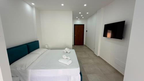 a white room with a bed with towels on it at San Lorenzo Palace in Reitani