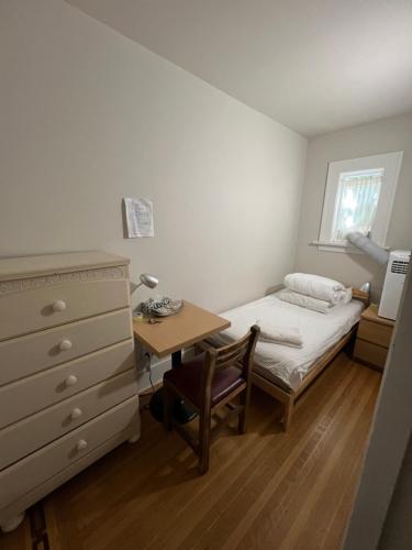 a small bedroom with a bed and a desk at Dunbar Home in Vancouver