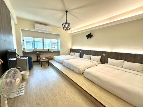 a bedroom with three beds and a fan at 客梢 Cushare #市政府商務住宿 #停車方便 #可包棟 in Tainan