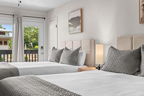two beds in a bedroom with a balcony at Suites at Waterside in Branson