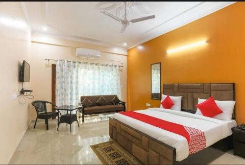 a bedroom with a bed and a table and a couch at Elite HomeZ in Greater Noida