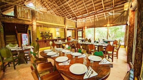 a large dining room with wooden tables and chairs at Hotel Puerta Calakmul in Conhuas