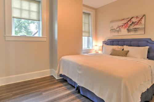 a bedroom with a large bed and two windows at Historic King James Unit 1 in Asheville