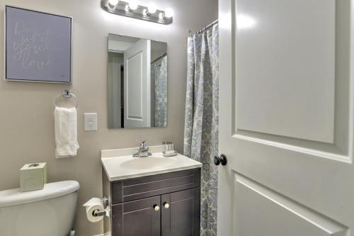 a bathroom with a sink and a toilet and a mirror at Historic King James Unit 1 in Asheville