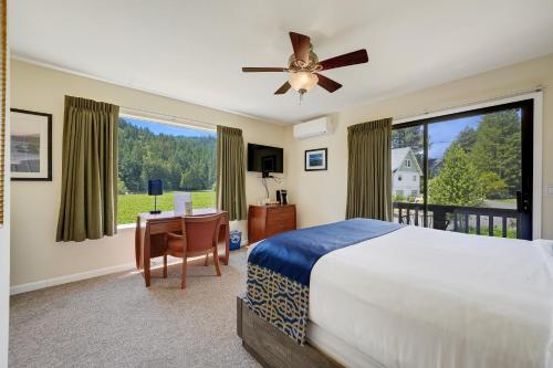 a bedroom with a bed and a desk and a large window at West Sonoma Inn & Spa in Guerneville