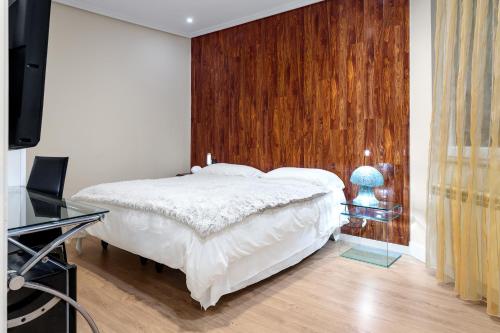 a bedroom with a bed and a desk and a television at Santacruz in Oviedo