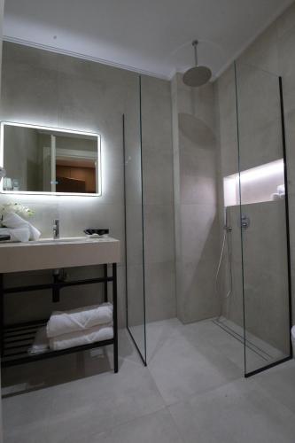 a bathroom with a sink and a shower at Hotel New City Tirana in Kamëz