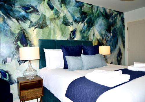 a bedroom with two beds with a blue and green wall at The Nest Hotel & Restaurant in Petersfield