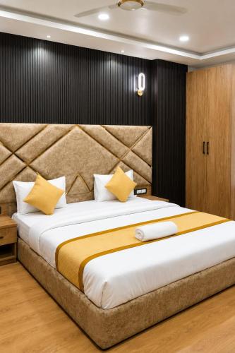 a bedroom with a large bed with yellow pillows at Hotel Aarambh By Ramayana Grand-Near Ram Mandir Ayodhya in Ayodhya