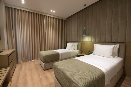 a hotel room with two beds and a television at Hotel New City Tirana in Kamëz