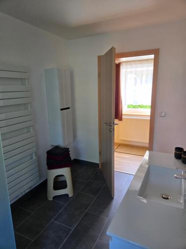 a bathroom with a sink and a door with a window at Am Rittergut Giesenstein Gartenblick in Bad Gottleuba